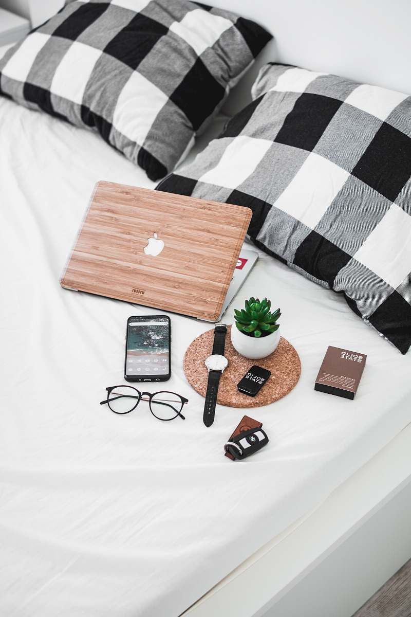 blanket smartphone, eyeglasses, watch, and vehicle fob on bed timișoara